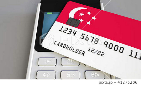 Payment or POS terminal with credit card featuring flag of Singapore. Singaporean retail commerce or 41275206