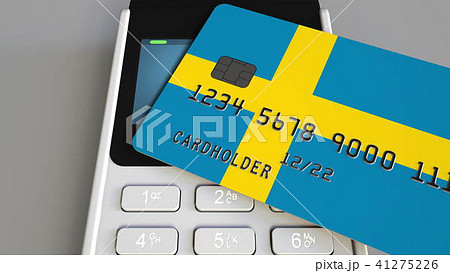 Payment or POS terminal with credit card featuring flag of Sweden. Swedish retail commerce or 41275226
