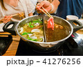 Sliced pork meat with chopsticks over hot pot 41276256