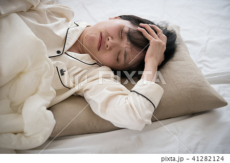 体調不良の若い日本人女性の写真素材