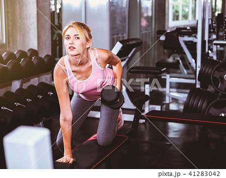Attractive woman training with dumbbell 41283042