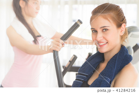 woman in sport wear and towel training with friend 41284216