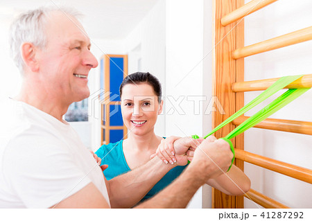 Physio doing shoulder exercises with senior man Physio doing shoulder exercises with senior man 41287292