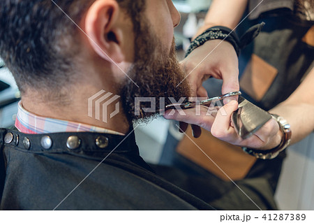Close-up of the head of a young man and the hands of a hairstylist Close-up of the head of a young man and the hands of a hairstylist 41287389