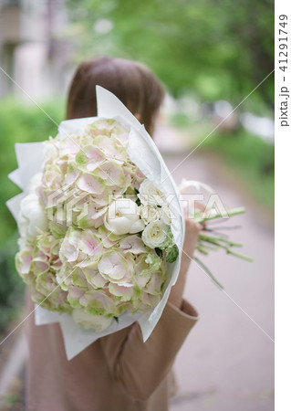 Young girl holding a beautiful spring bouquet. flower arrangement with hydrangea and peonies. Color 41291749