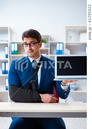 Businessman with broken arm working in office Businessman with broken arm working in office 41295022