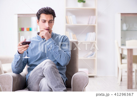 Young man drinking wine at home 41296367