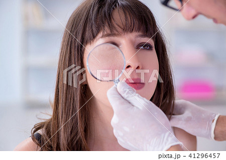 Doctor examining the skin of female patient Doctor examining the skin of female patient 41296457