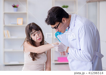 Doctor examining the skin of female patient 41296514