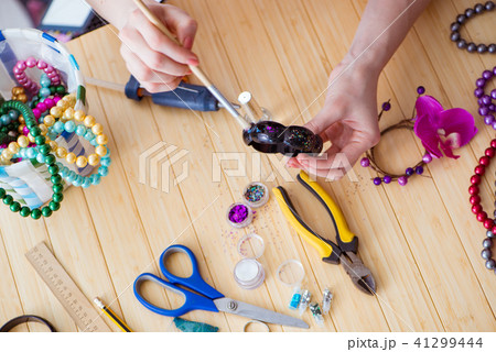 Woman making jewelry at home Woman making jewelry at home 41299444