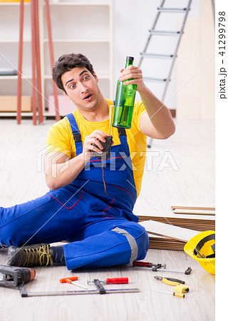 Floor repairman drinking alcohol during break 41299798