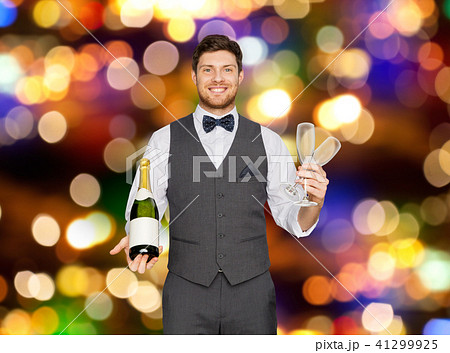 man with bottle of champagne and glasses at party man with bottle of champagne and glasses at party 41299925