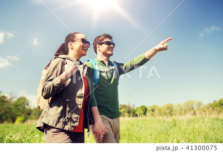 happy couple with backpacks hiking outdoors 41300075
