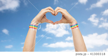male hands with gay pride wristbands showing heart 41300318