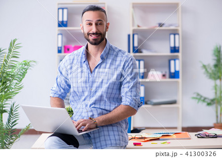 Young designer working in his studio on new project 41300326