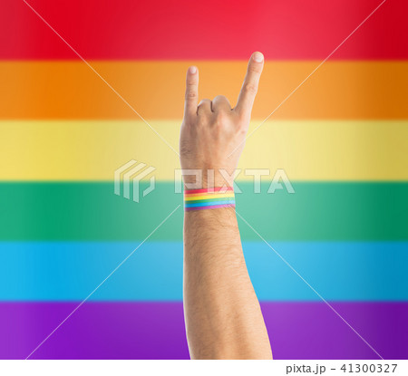 hand with gay pride rainbow wristband shows rock 41300327