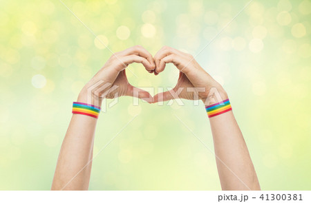 male hands with gay pride wristbands showing heart 41300381