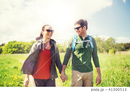 happy couple with backpacks hiking outdoors 41300513