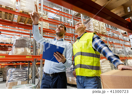 worker and businessman with clipboard at warehouse 41300723