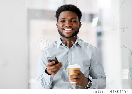 businessman with smartphone and coffee at office 41301152