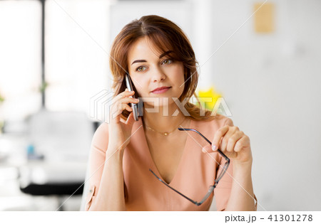 businesswoman calling on smartphone at office businesswoman calling on smartphone at office 41301278