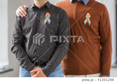 close up of couple with gay pride rainbow ribbons 41301286