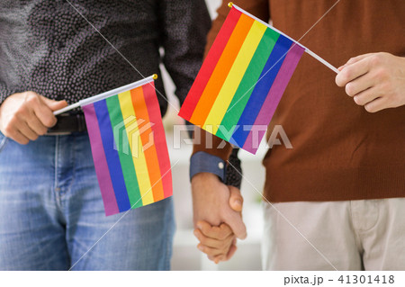 male couple with gay pride flags holding hands 41301418