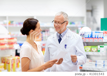 woman and apothecary with prescription at pharmacy 41301543