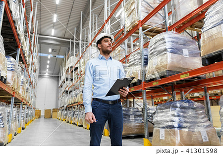 businessman in helmet with clipboard at warehouse 41301598