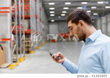 businessman with smartphone at warehouse businessman with smartphone at warehouse 41301605