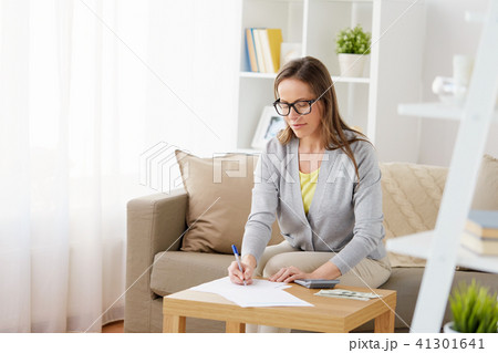 woman with papers, money and calculator at home 41301641