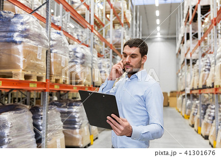 businessman calling on smartphone at warehouse businessman calling on smartphone at warehouse 41301676