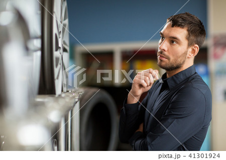 male customer choosing wheel rims at car service 41301924