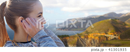 close up of woman listening to music in earphones close up of woman listening to music in earphones 41301935