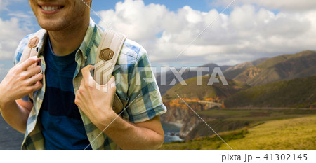 close up of man with backpack over big sur coast 41302145