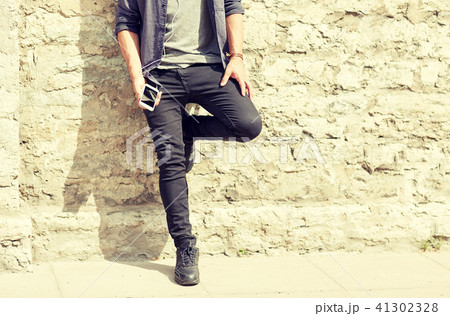 man with earphones and smartphone on street 41302328