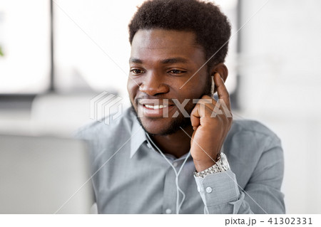 businessman with earphones and computer at office 41302331