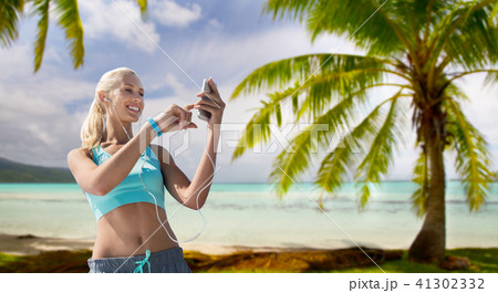 woman with smartphone and earphones doing sports 41302332