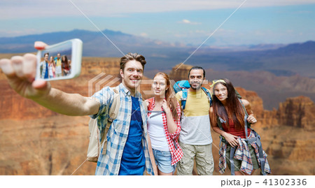 friends with backpack taking selfie by smartphone 41302336