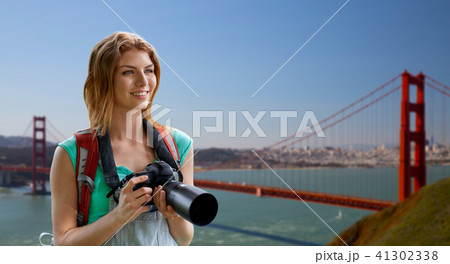 woman with backpack and camera over golden gate 41302338