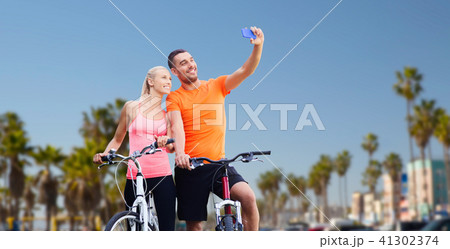 couple with bicycles taking selfie by smartphone couple with bicycles taking selfie by smartphone 41302374