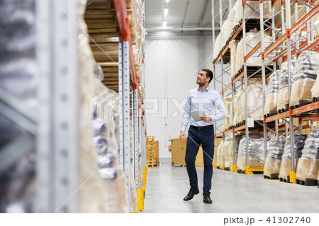 happy businessman with tablet pc at warehouse happy businessman with tablet pc at warehouse 41302740