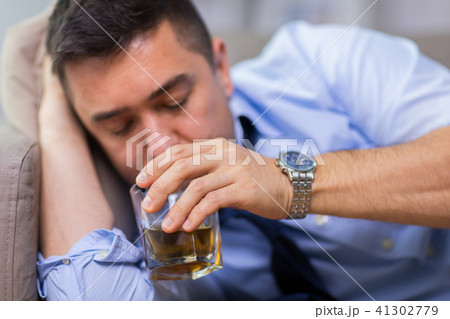 alcoholic lying on sofa and drinking whiskey alcoholic lying on sofa and drinking whiskey 41302779
