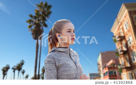 woman with earphones running over venice beach woman with earphones running over venice beach 41302868