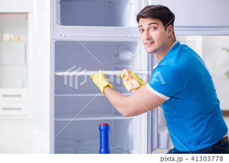 Man cleaning fridge in hygiene concept Man cleaning fridge in hygiene concept 41303778