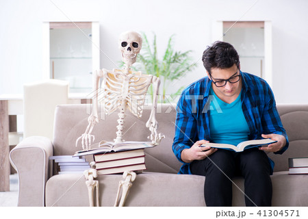 Student studying with skeleton preparing for exams Student studying with skeleton preparing for exams 41304571