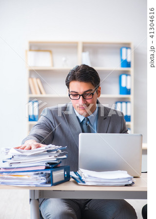 Extremely busy businessman working in office 41304616