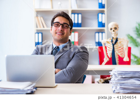 Businessman working with skeleton in office 41304654