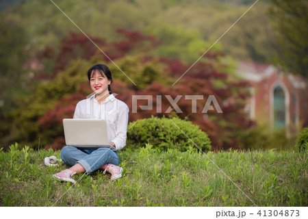 女子大生 屋外 ノートパソコンの写真素材