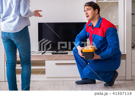 Repairman repairing tv at home Repairman repairing tv at home 41307119